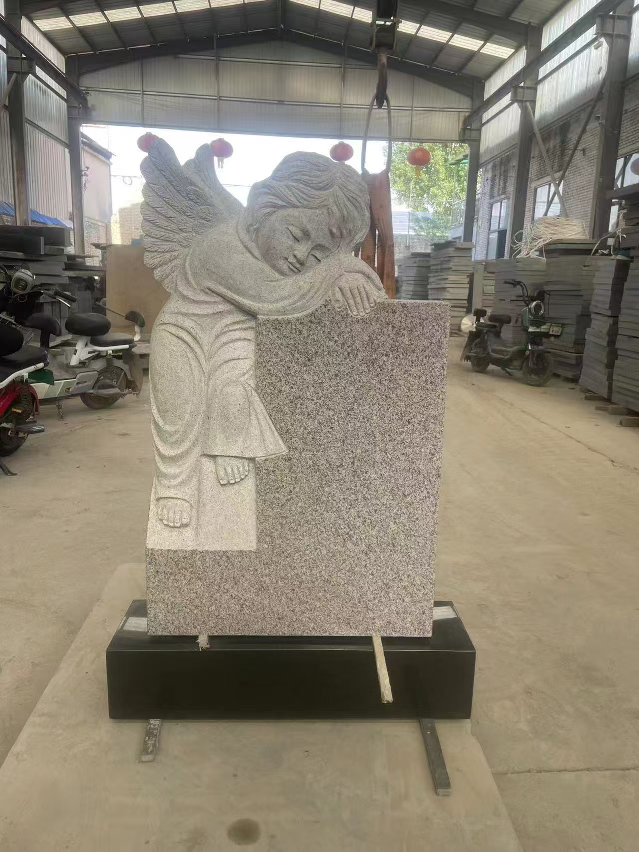 grey granite headstone with a white angel statue.jpg