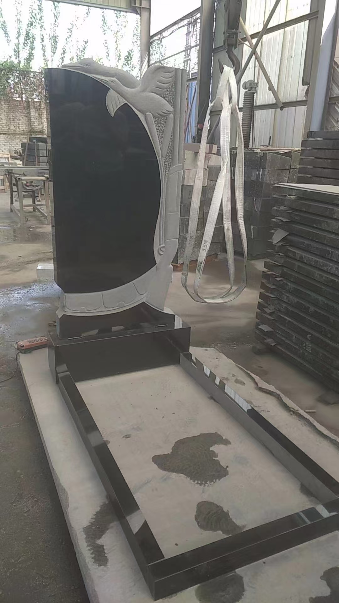 black granite headstone with white swan carved.jpg